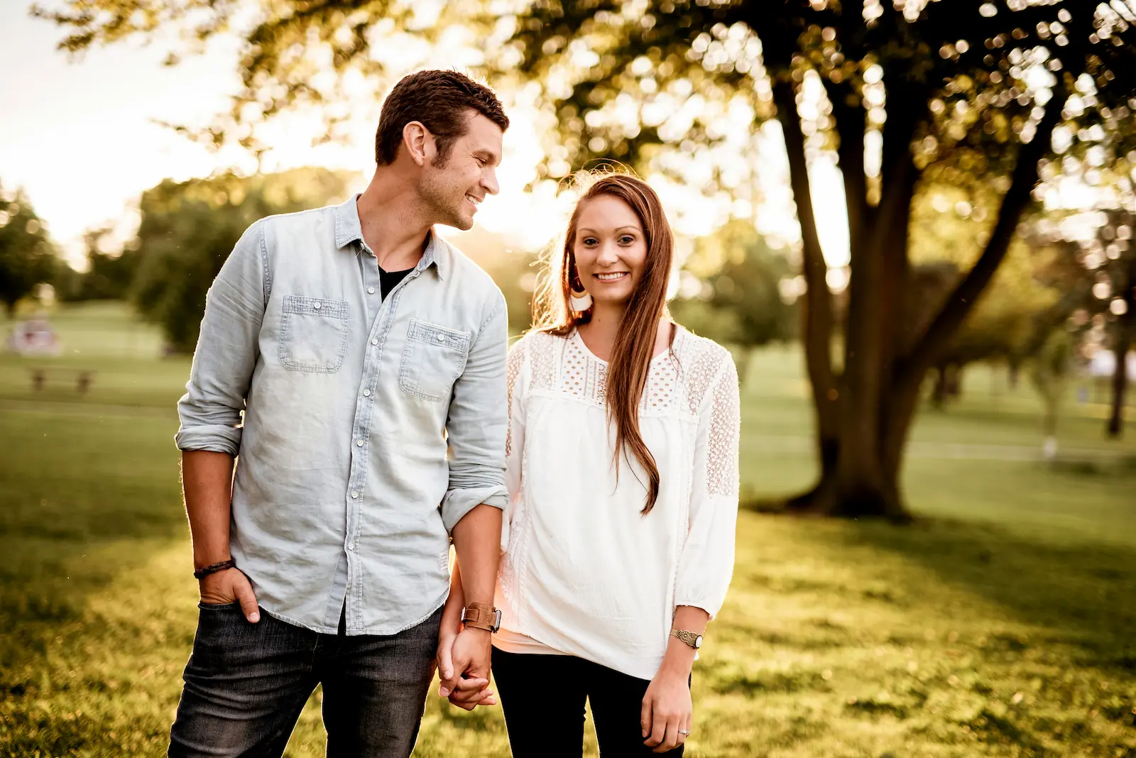 Smiling couple holding hands outdoors at sunset, symbolising genuine relationships on Netthub
